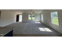 Bright, open living room with plush carpet, neutral walls, and large windows allowing natural light at 166 Coharie Dr, Lillington, NC 27546