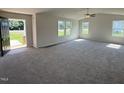 Bright, open living room with plush carpet, neutral walls, and large windows allowing natural light at 166 Coharie Dr, Lillington, NC 27546