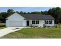 Charming single-story home featuring a classic white facade, a two-car garage, and a neatly maintained lawn at 179 Coharie Dr, Lillington, NC 27546