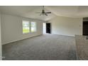 Bright living room with neutral carpet, a ceiling fan, large windows, and a vaulted ceiling at 179 Coharie Dr, Lillington, NC 27546