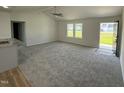 Open-concept living room with carpet, large windows, vaulted ceilings, and easy access to the kitchen at 179 Coharie Dr, Lillington, NC 27546