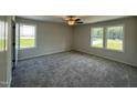 Bright bedroom features plush carpeting, ceiling fan, and large windows with scenic views at 206 Coharie Dr, Lillington, NC 27546