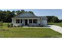 Charming single-story home with a well-manicured lawn and a covered front porch at 206 Coharie Dr, Lillington, NC 27546