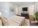 This bedroom is virtually staged, featuring a modern dresser, tv and neutral colors throughout at 216 E Hinton St, Clayton, NC 27520