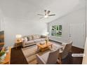 Bright living room with hardwood floors, neutral paint, and a large window, staged with modern furniture at 216 E Hinton St, Clayton, NC 27520