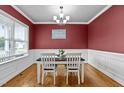 Dining room featuring hardwood floors, a modern chandelier, and a view to the front yard at 240 Paddy Ln, Youngsville, NC 27596