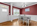 Dining room featuring hardwood floors, a modern chandelier, and a view to the front yard at 240 Paddy Ln, Youngsville, NC 27596