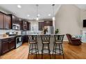 Spacious kitchen with dark cabinetry, granite countertops, stainless steel appliances, and bar seating at 240 Paddy Ln, Youngsville, NC 27596
