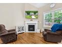 Cozy living room with a fireplace, hardwood floors, and lots of natural light at 240 Paddy Ln, Youngsville, NC 27596