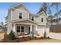 Charming two-story home featuring a spacious two-car garage and a welcoming front porch with stone accents at 27 Cribbs Ln, Middlesex, NC 27557