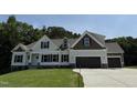 Newly built house with a modern design, beautiful siding, and an attached garage at 322 Busterfield Ct, Benson, NC 27504