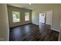 Sunlit flex room with dark wood floors, a large window, and a view to the front door at 322 Busterfield Ct, Benson, NC 27504