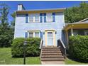 Charming blue two-story home with yellow trim, blue shutters, brick steps, and green landscaping at 3510 Rawdon Dr, Durham, NC 27713