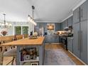 Well-designed kitchen featuring a butcher block island, blue cabinets, and stainless steel appliances at 3620 Arrowwood Dr, Raleigh, NC 27604