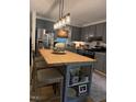 Stylish kitchen featuring gray cabinets, stainless steel appliances, a butcher block island and pendant lighting at 3620 Arrowwood Dr, Raleigh, NC 27604