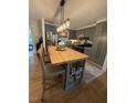 Bright kitchen featuring gray cabinets, stainless steel appliances, a butcher block island and a light fixture at 3620 Arrowwood Dr, Raleigh, NC 27604