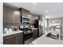 Modern kitchen features stainless steel appliances, gray cabinets, and quartz countertops at 408 Grand Silo Rd, Garner, NC 27603