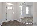 Bright entryway featuring modern wood floors, a stylish front door, and an open doorway leading to a carpeted room at 412 Longleaf Glen Lane, Zebulon, NC 27597