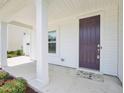 Inviting front porch with white columns, a dark door, and landscaped flower bed at 514 Bonville Ct, Fuquay Varina, NC 27526
