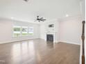 Open-concept living room featuring fireplace, hardwood floors, ceiling fan, and great light at 514 Bonville Ct, Fuquay Varina, NC 27526