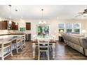 Open concept dining room flows into kitchen, featuring modern chandelier and ample seating at 59 White Quartz Pl, Fuquay Varina, NC 27526
