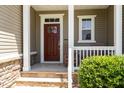 Inviting front porch features stone accents, white columns, and cozy seating area at 59 White Quartz Pl, Fuquay Varina, NC 27526