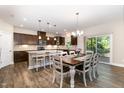 Open kitchen with stainless appliances, granite counters, tile backsplash, and dark wood cabinets at 59 White Quartz Pl, Fuquay Varina, NC 27526