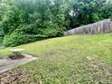Expansive backyard with lush green grass, a sturdy fence, and mature trees at 5911 Endsley Ct, Raleigh, NC 27610