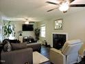 Cozy living room features dark wood floors, modern furniture, fireplace and multiple ceiling fans at 8 Woodsprite Ct, Durham, NC 27703