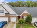 Charming brick townhome with a well-manicured lawn, colorful flower beds, and a two-car garage at 10404 Dapping Dr, Raleigh, NC 27614