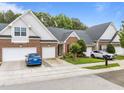 Charming brick townhome with a well-manicured lawn, colorful flower beds, and a two-car garage at 10404 Dapping Dr, Raleigh, NC 27614