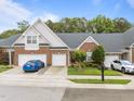 Charming brick townhome with a well-manicured lawn, colorful flower beds, and a two-car garage at 10404 Dapping Dr, Raleigh, NC 27614