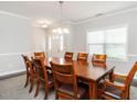 Formal dining room featuring a large wood table with seating for eight and elegant lighting at 105 Pink Dogwood Ln, Mebane, NC 27302