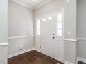 Bright foyer with hardwood floors, a white front door with sidelights and upper transom windows at 105 Pink Dogwood Ln, Mebane, NC 27302