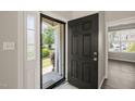 Welcoming entryway featuring a stylish black front door, sidelight window, and view of the front yard at 107 Meeting Hall Dr, Morrisville, NC 27560