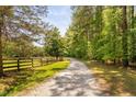 Gravel driveway winding through a tree lined path to residence at 108 Cedarwood Dr, Louisburg, NC 27549