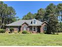 Inviting brick home with well-manicured lawn, mature trees, and charming architectural details at 108 Cedarwood Dr, Louisburg, NC 27549