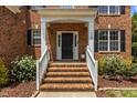 Inviting front porch with brick steps, white railings, and decorative plantings at 110 Fairchild Downs Pl, Cary, NC 27518