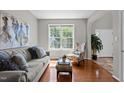 Cozy living room with hardwood floors, large window, and neutral decor at 110 Fairchild Downs Pl, Cary, NC 27518