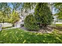 Expansive front yard with lush green grass, mature trees and shrubs, and a white picket fence at 111 Chancellors Ridge Dr, Durham, NC 27713