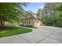 A side view showcasing the home's stone and shingle exterior and attached garage at 1211 New Grissom Way, Wake Forest, NC 27587