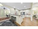Open kitchen with white cabinets, granite countertops, and breakfast bar seating at 1211 New Grissom Way, Wake Forest, NC 27587