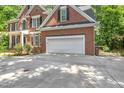 Spacious two-car garage attached to a brick home with a well-maintained driveway and green surroundings at 123 W Camden Forest Dr, Cary, NC 27518