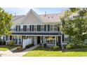 Charming townhouse featuring gray siding, black shutters, and a well-manicured front yard at 1313 Legacy Greene Ave, Wake Forest, NC 27587
