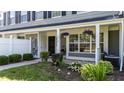 Inviting front porch with decorative plants and flowers, perfect for relaxation at 1313 Legacy Greene Ave, Wake Forest, NC 27587