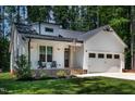 Inviting front porch with cozy seating, stone accents, and a classic front entry door at 136 Hatchet Cv, Louisburg, NC 27549