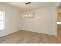 Elegant dining room showcasing wainscoting, hardwood floors, and a stylish chandelier at 14 Duck Bill Trl, Pittsboro, NC 27312