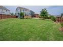 Expansive backyard featuring lush green grass, a wooden fence, and an outdoor pergola at 2020 Cotton Barn Ct, Wendell, NC 27591