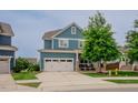 Charming blue home with a two-car garage, manicured lawn, and welcoming front porch at 2020 Cotton Barn Ct, Wendell, NC 27591