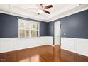 Spacious dining room featuring hardwood floors, elegant trim, a ceiling fan, and a large window for ample natural light at 213 Florence Dr, Clayton, NC 27527